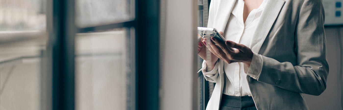 A woman looks on a smartphone