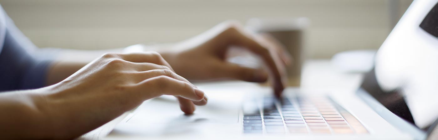 A closeup of someone typing on a laptop