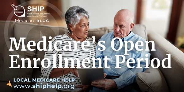 An older man and woman sitting on a couch looking at a tablet